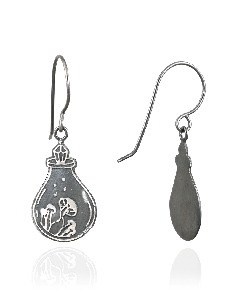 Silver earrings with a design of a potion bottle, with a crystal top, containing a mushrooms on a white background.