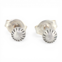 Pair of mini silver textured dot ear posts on a white background