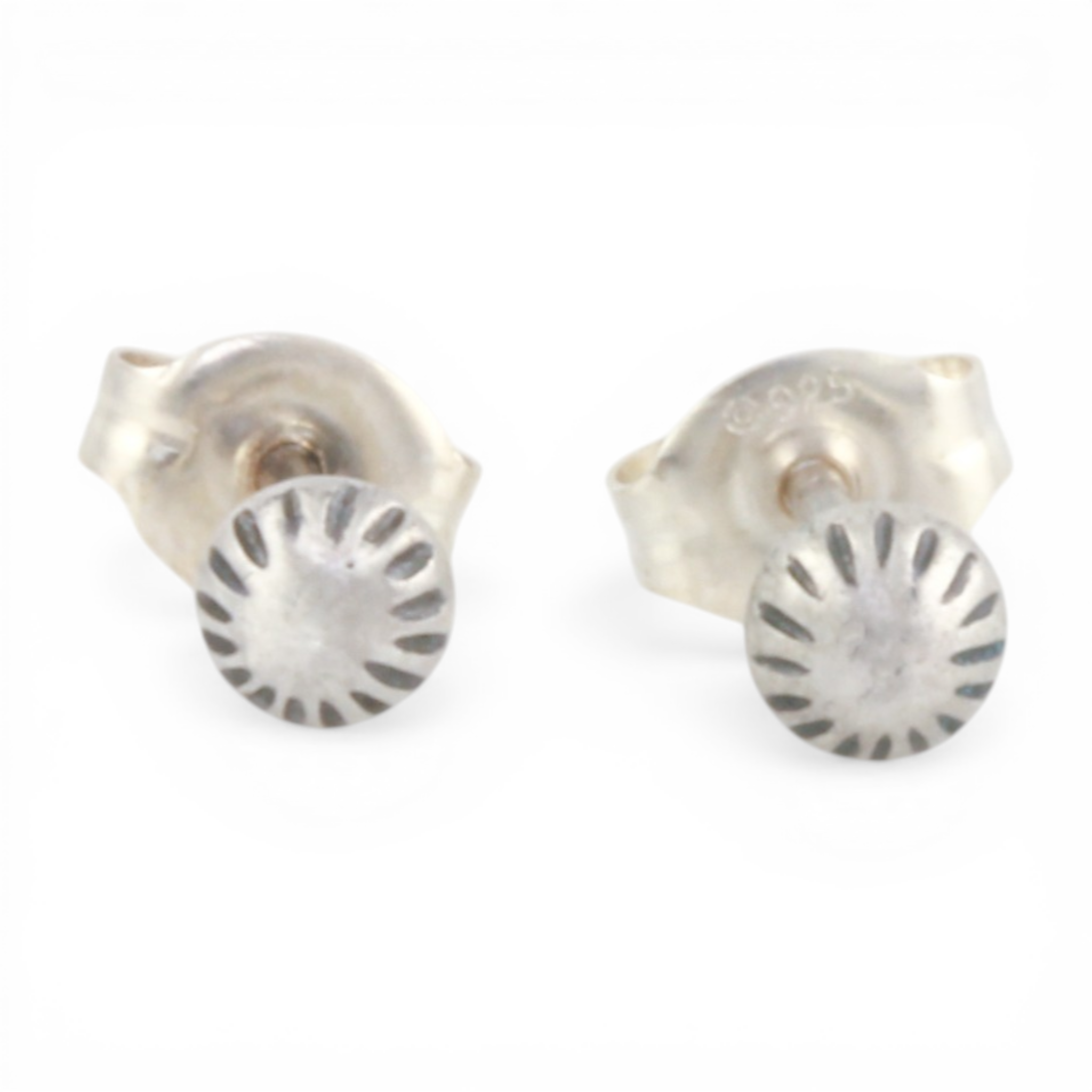 Pair of mini silver textured dot ear posts on a white background