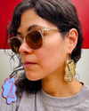 Artist modeling Torchin' Ice v1 Medium Brass  dangle earrings.
