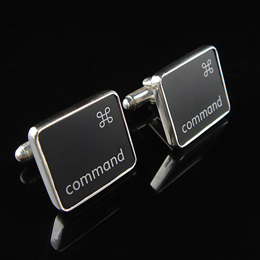 Black and silver cufflinks with 'command' branding on a black background