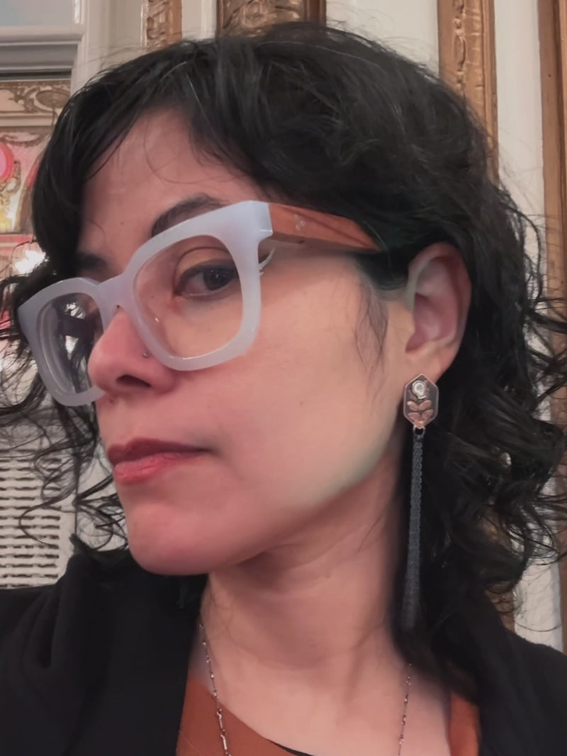 Video: Pair of copper hexagon shaped earrings with silver skull and chain fringe details, modeled by the artist (real human).