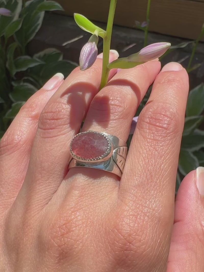 Video: Artist modeling a silver wide ring band ring with a pink strawberry quartz gemstone.