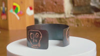 360 of a handmade copper cuff bracelet with artisan signature oxidized skull designs on a rotating white surface.  Bracelet by Lauren Anabela of Creative Dexterity