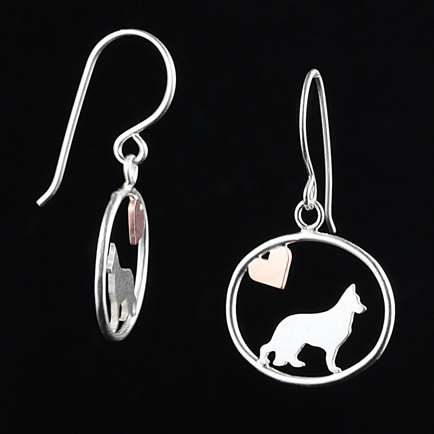 Sterling silver German Shepherd dangle earrings with a small copper heart inside oval frames, matte finish on black background.