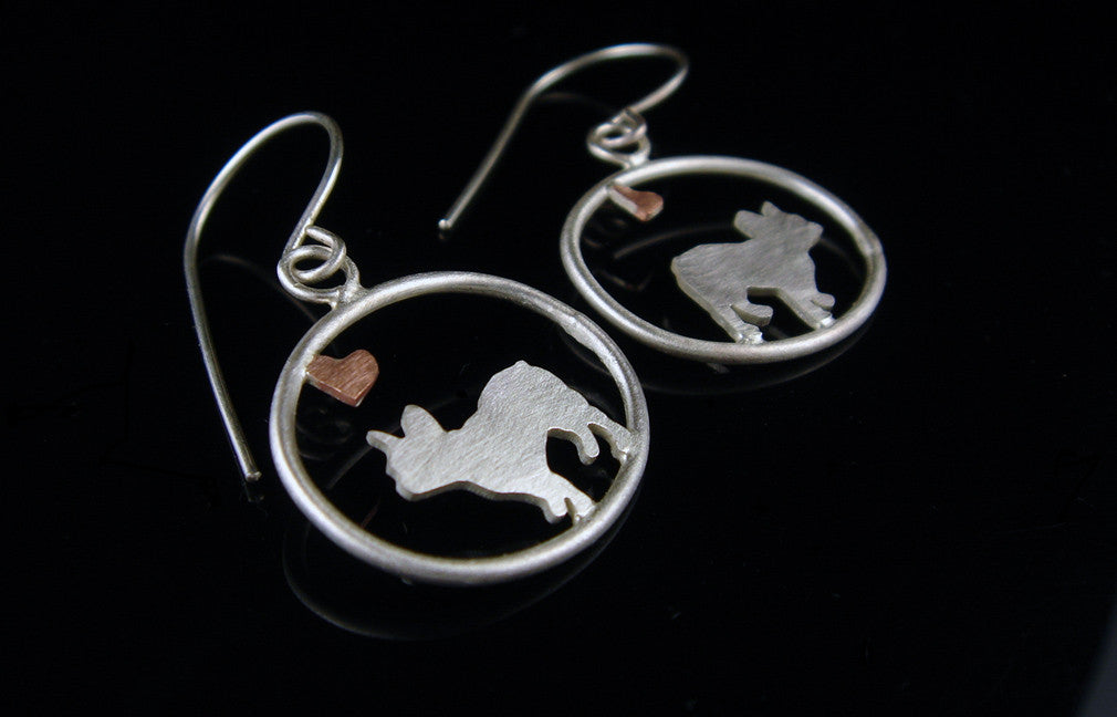Sterling silver French Bulldog dangle earrings with copper heart inside oval frame, matte finish on black background.