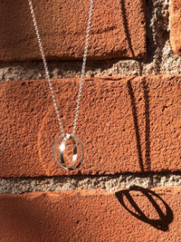 Absolute Cycle - Geometric Orb Pendant by Creative Dexterity - suspended on chain with shadow in background