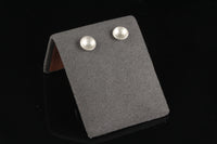 Handmade tiny domed cup sterling silver stud earrings - on display view