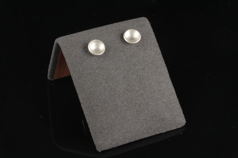 Handmade tiny domed cup sterling silver stud earrings - on display view